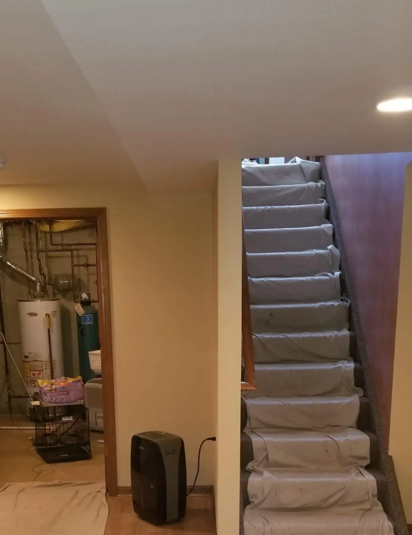 Drop cloths laid over basement stairs and laminate flooring to protect the home during install.