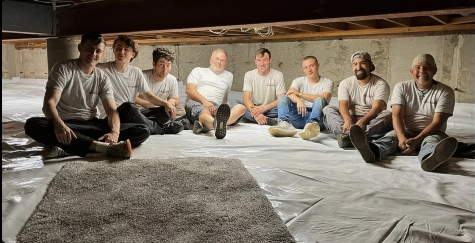 The American Radon Systems crew sitting together in a fully encapsulated crawl space during a job in Palos Hills, Illinois.